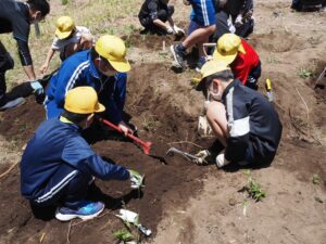 幸夫さんたちが行う歴史の授業で、白川町の遺跡発掘をする小学生。