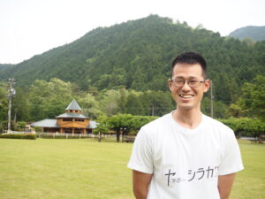 「ヤッホーシラカワ」と印字された自作Tシャツを着る西野さん