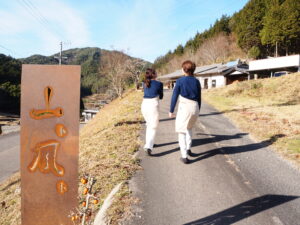 入口の前にある看板を背に歩く、めぐみさんさんと、姉の真奈巳さん