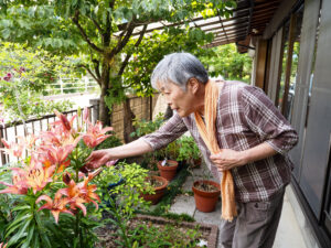 家庭菜園を触る康子さん