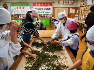 地域の小学生に手揉みを教える彼男さん