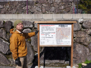 大岩巣登山道の看板の前に立つ清水さん