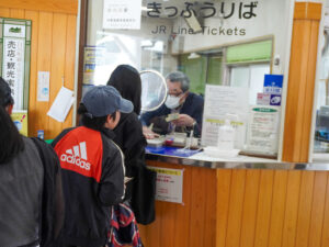 白川口駅で、切符を買うために並んでいる子どもたち