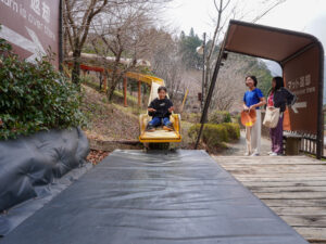 『下呂温泉合掌村』の森のすべり台を楽しむ様子
