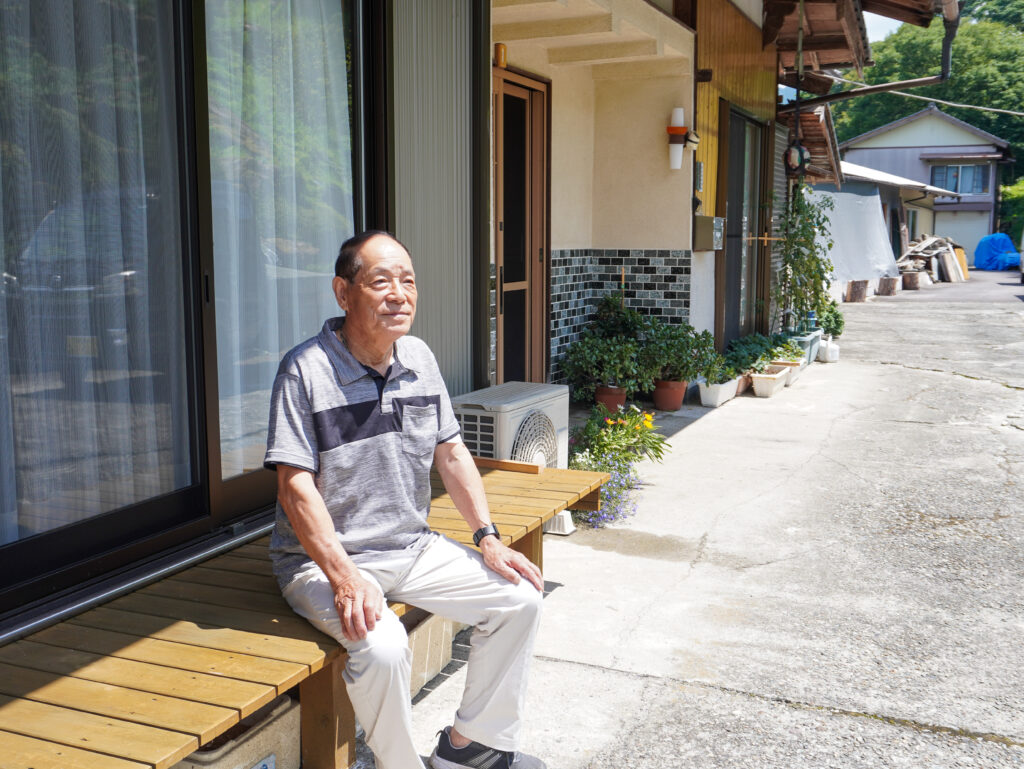ご自宅の縁側に座る博幸さん